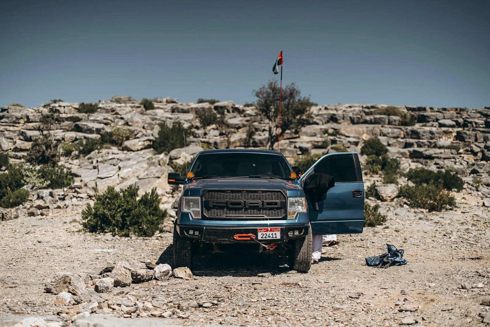 Photo by Eslam Mohammed Abdelmaksoud Off-road truck adventure in Oman's rocky desert landscape under clear skies.