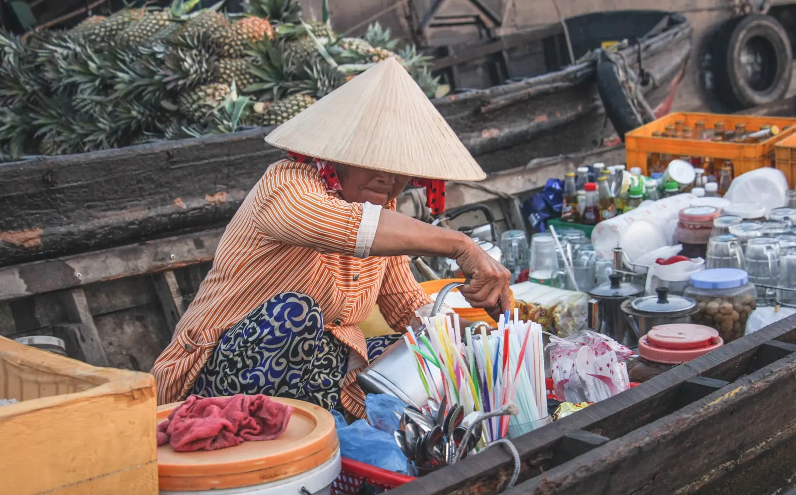 a woman sitting in a boat filled with lots of items