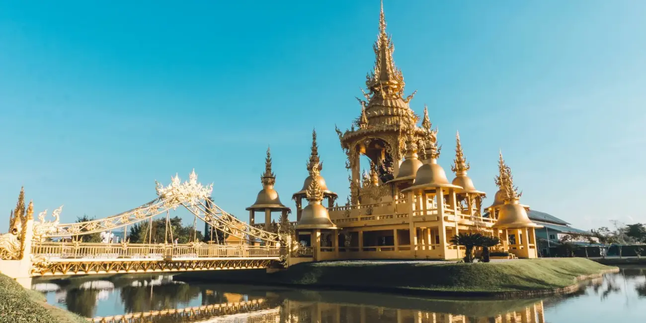 a large golden building sitting on top of a lake