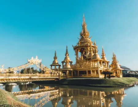 a large golden building sitting on top of a lake
