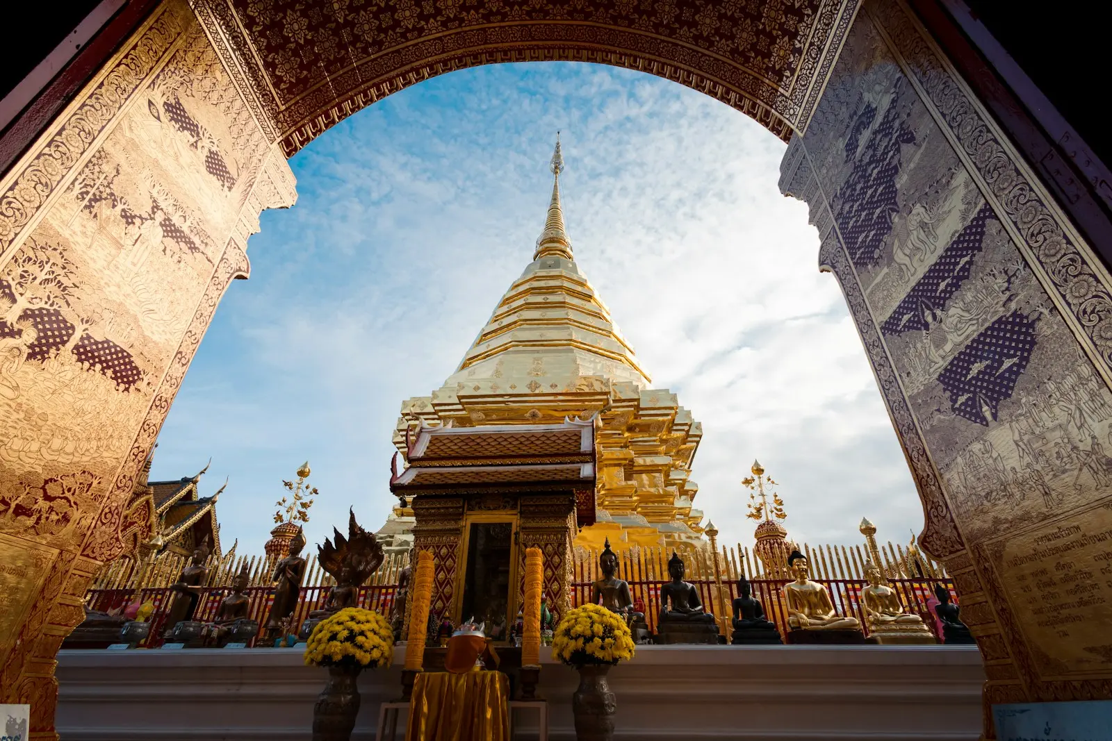 Photo by Nat Weerawong An arch leading into a temple with a sky in the background