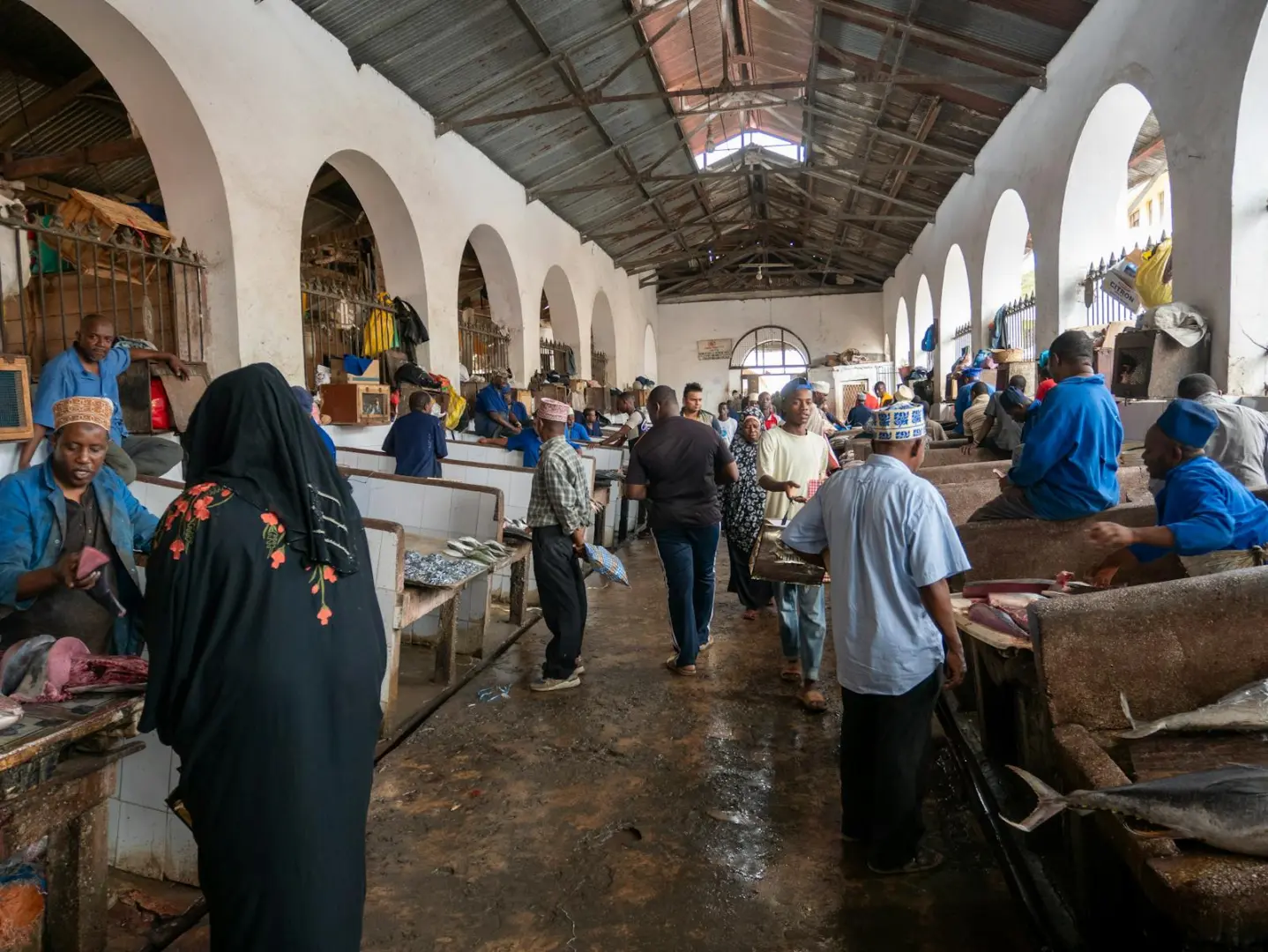 People engaged in lively trade inside a spacious fish market hall, showcasing local culture.