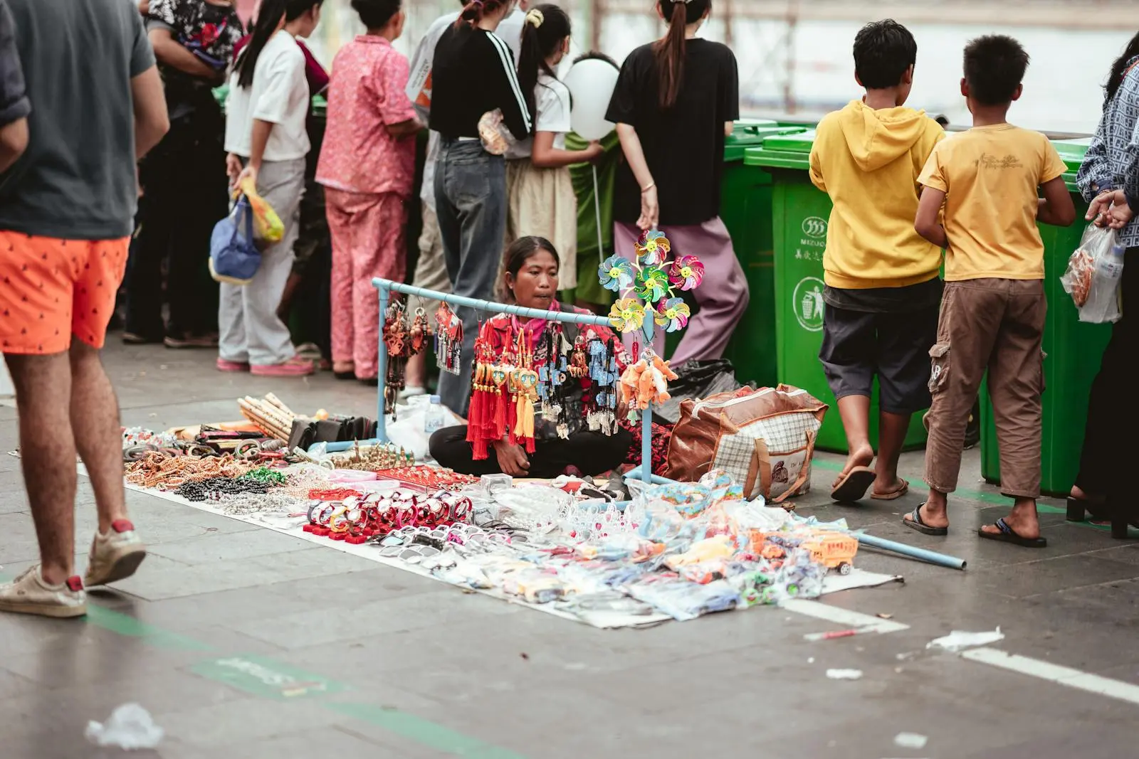 A street vendor in Phnom Penh displays a variety of handcrafted goods on the pavement.