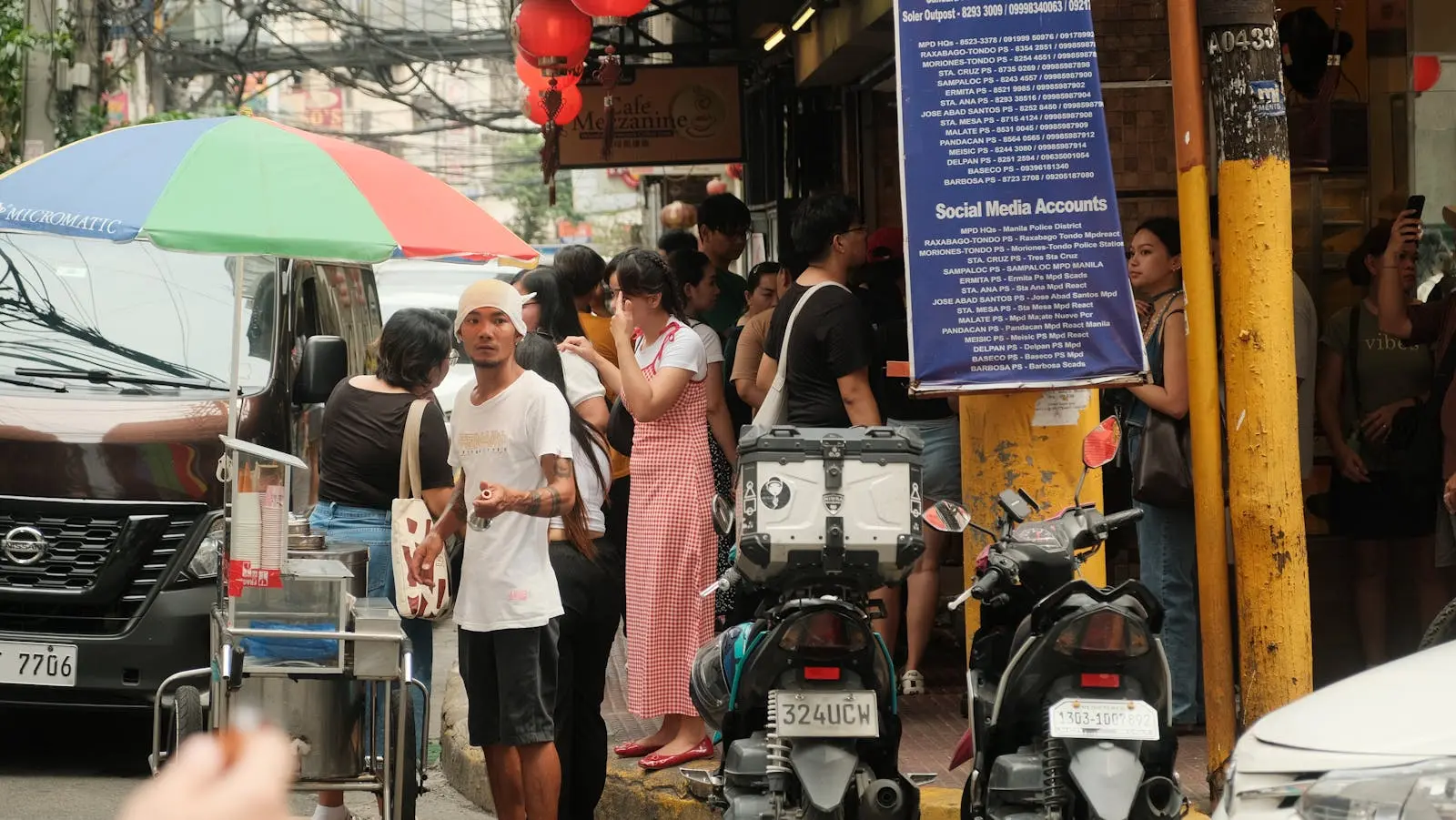 Vibrant street scene in Manila's Chinatown with people and motorcycles.