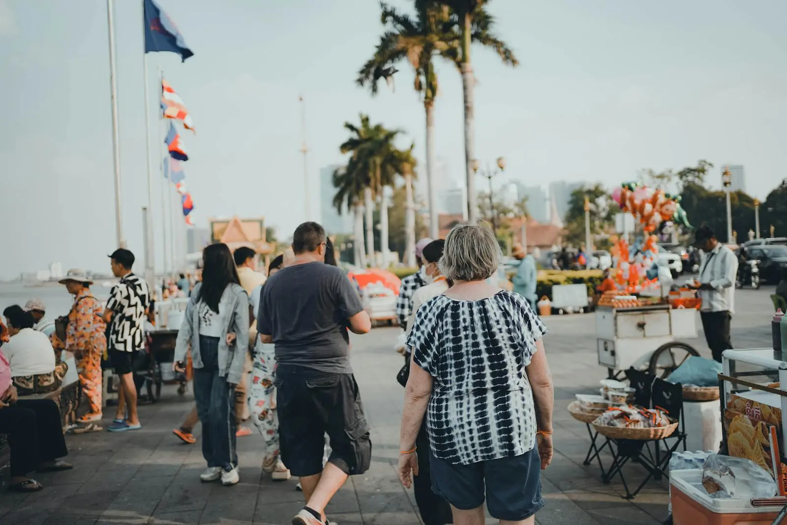 Exploring the lively riverside area of Phnom Penh, Cambodia, with bustling street vendors.