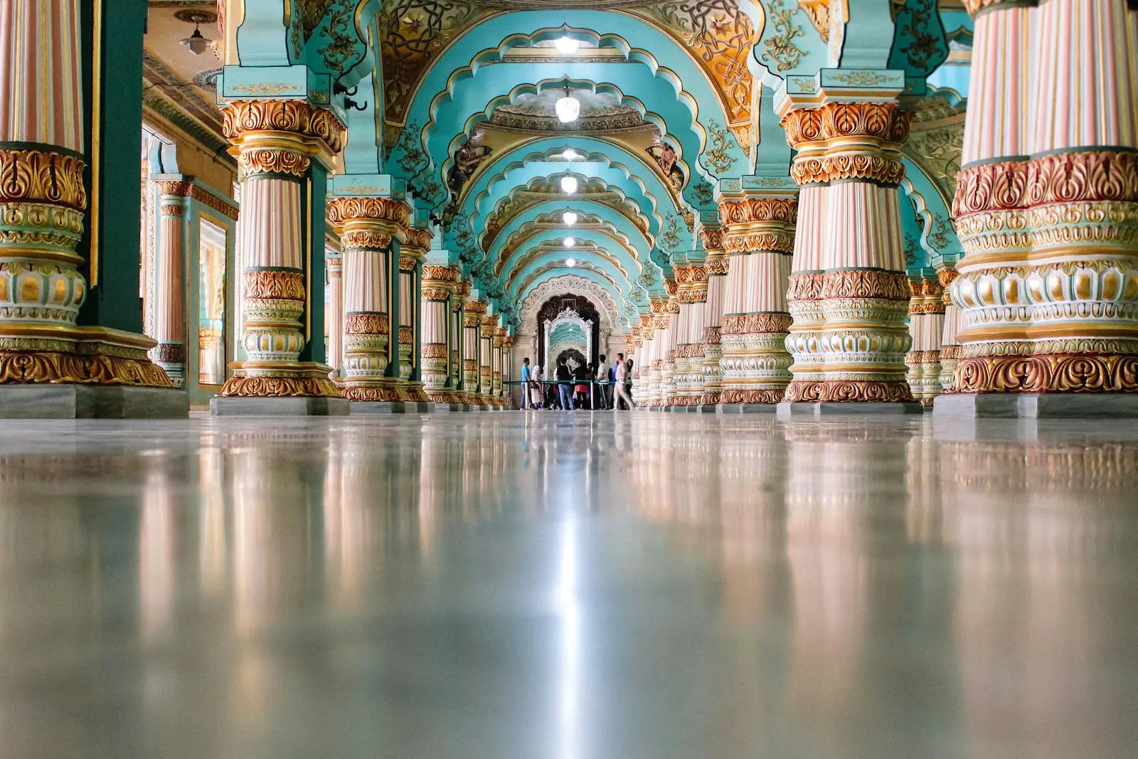Explore the majestic interiors of Mysore Palace's exquisite turquoise hall with ornate columns.