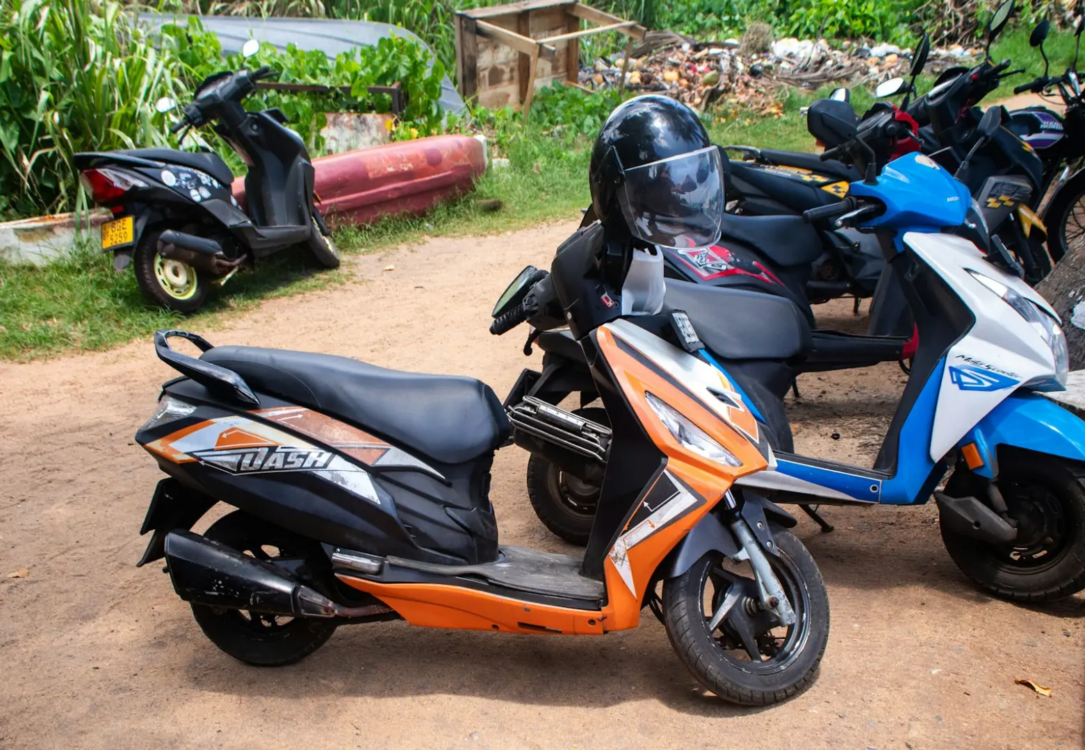 Several scooters are parked outside in a row.