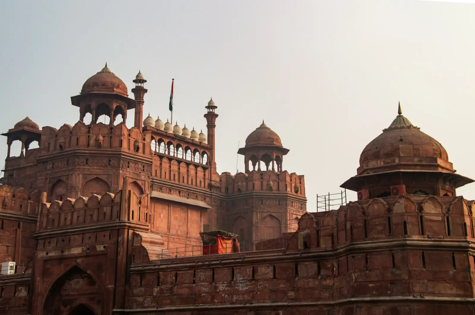 Red sandstone fort with domed towers and battlements