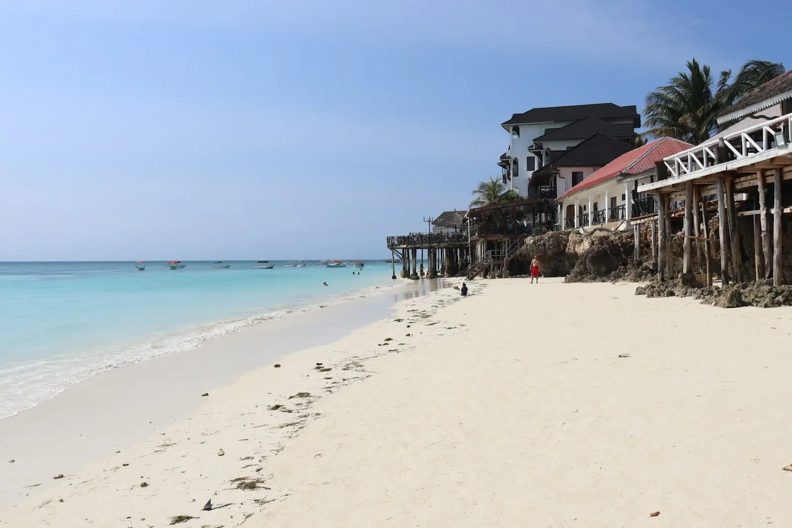 A white sandy beach with houses on it