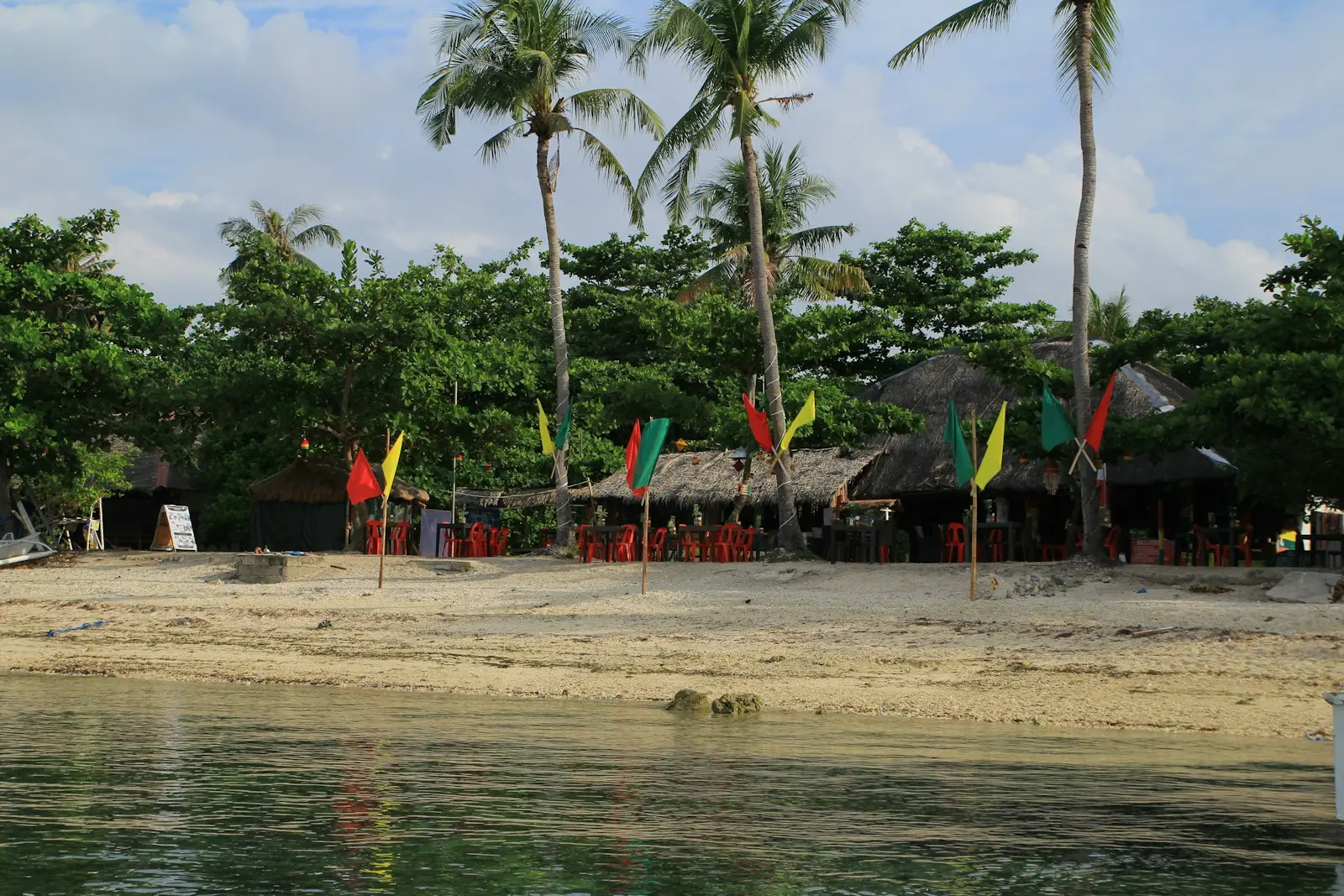 Beach with palm trees and a restaurant.