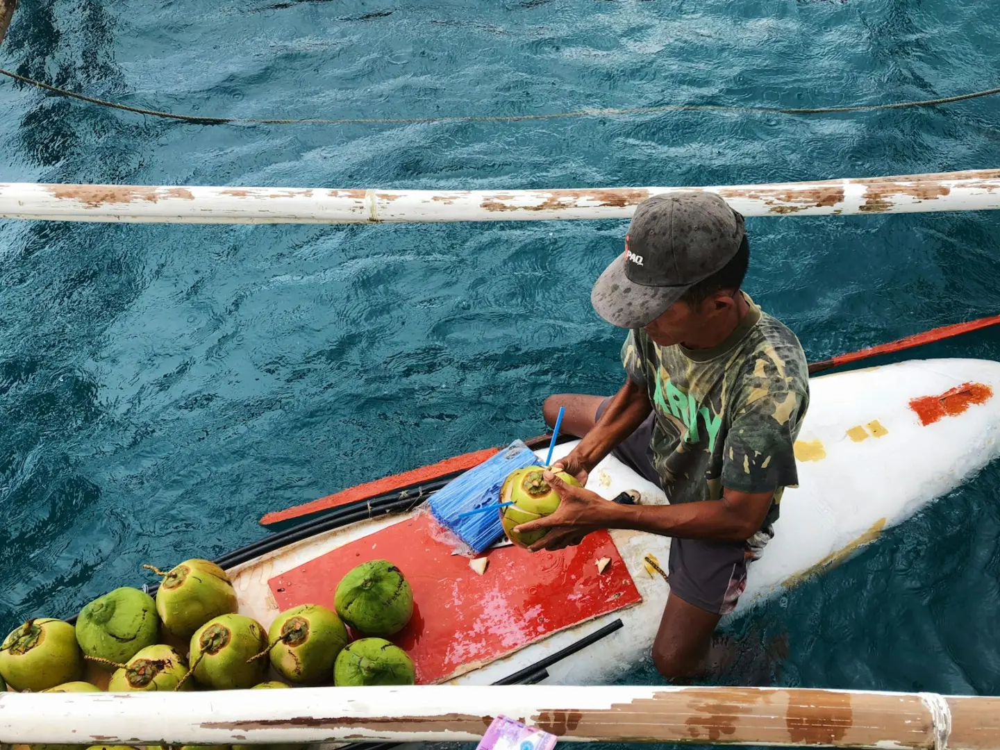 Photo by Lars Zhang man holding coconut on the boat