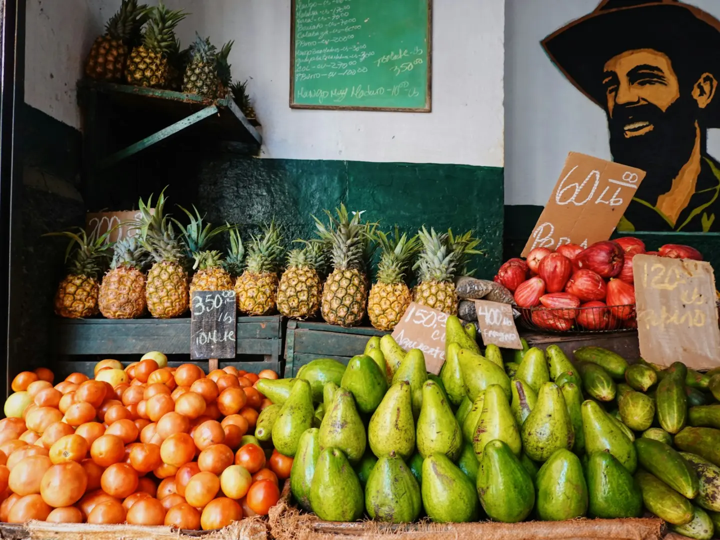 A fruit stand with pineapples, oranges, bananas, and other fruits