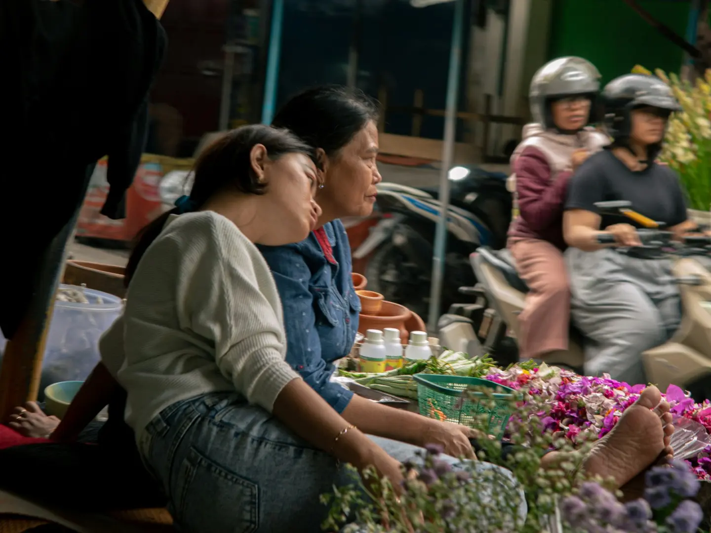 People resting near flowers at night market