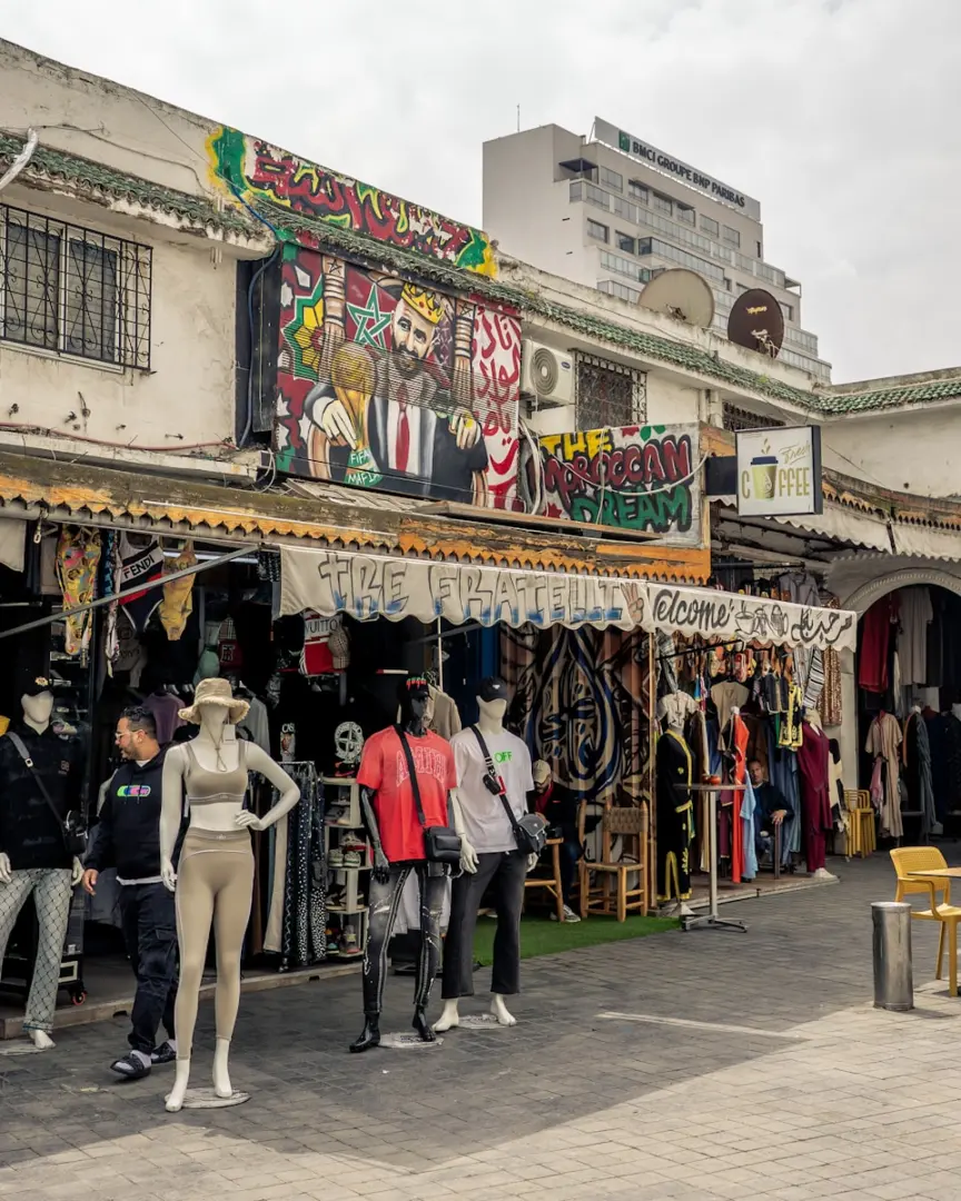 A bustling street market displays clothing and art.