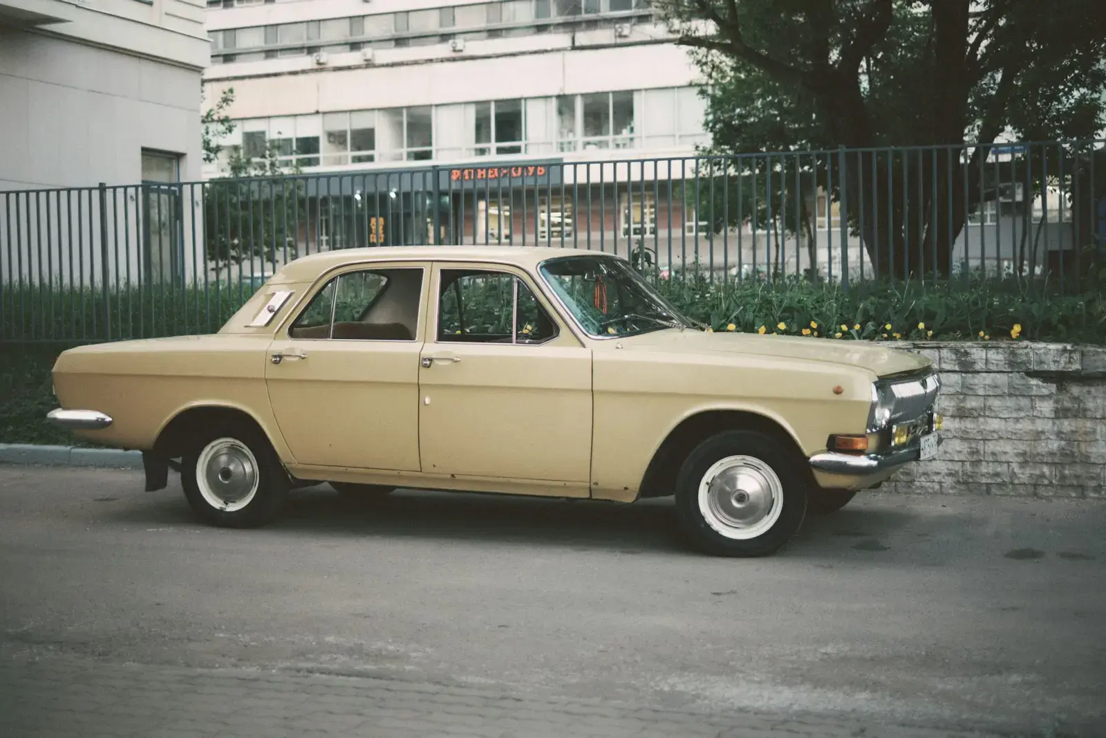 Photo by Jasper a tan car parked in front of a building