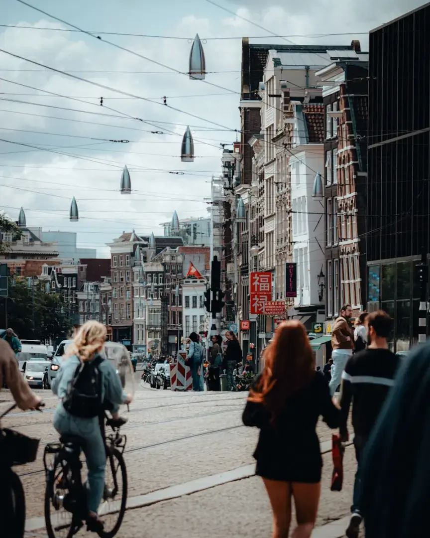Photo by Sara Ruffoni People and bicycles on a street in amsterdam.