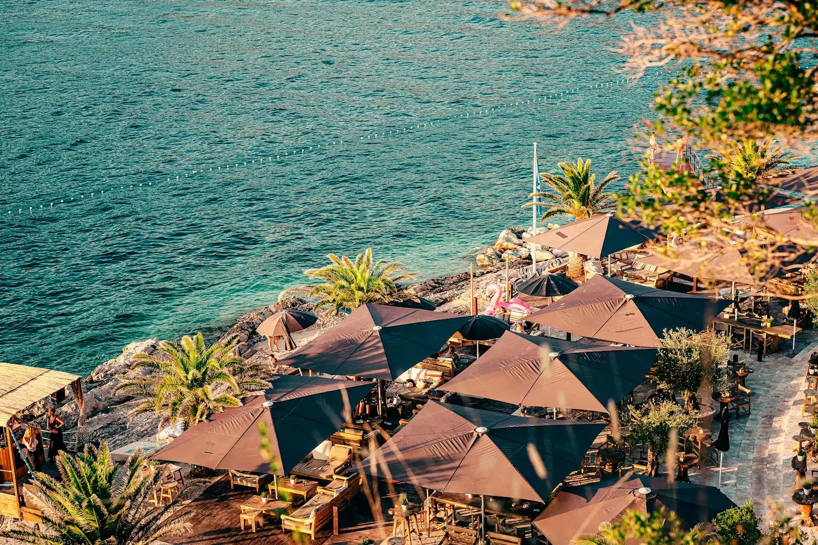 Aerial view of a beachfront restaurant with umbrellas on the Adriatic Sea in Dubrovnik, Croatia.