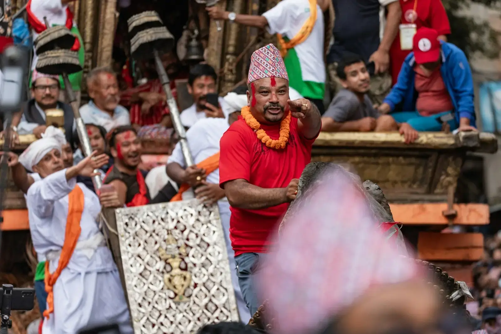 Man in red shirt leads procession with sword