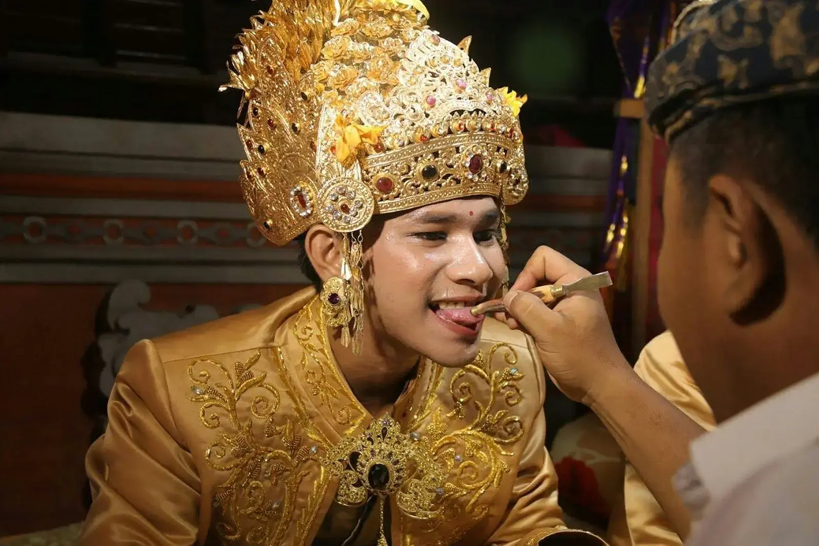 Photo by agung alit man wearing gold head dress opening his mouth