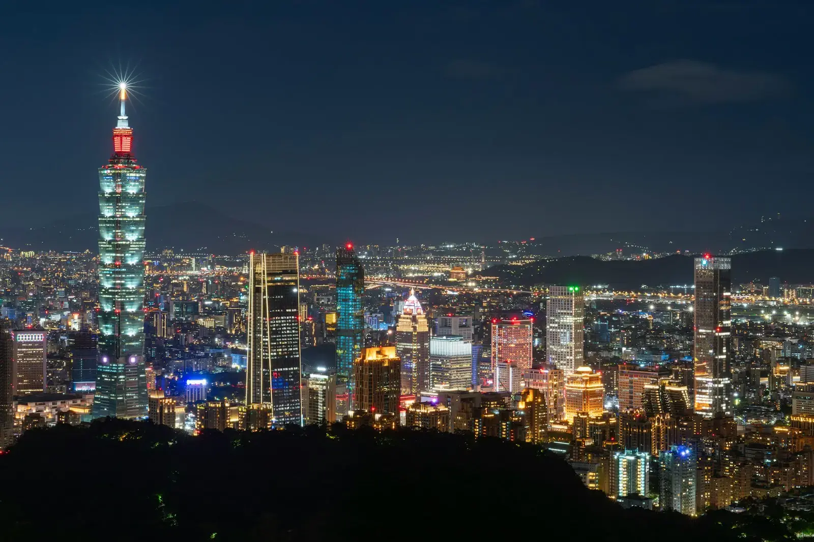 A view of a city at night from the top of a hill