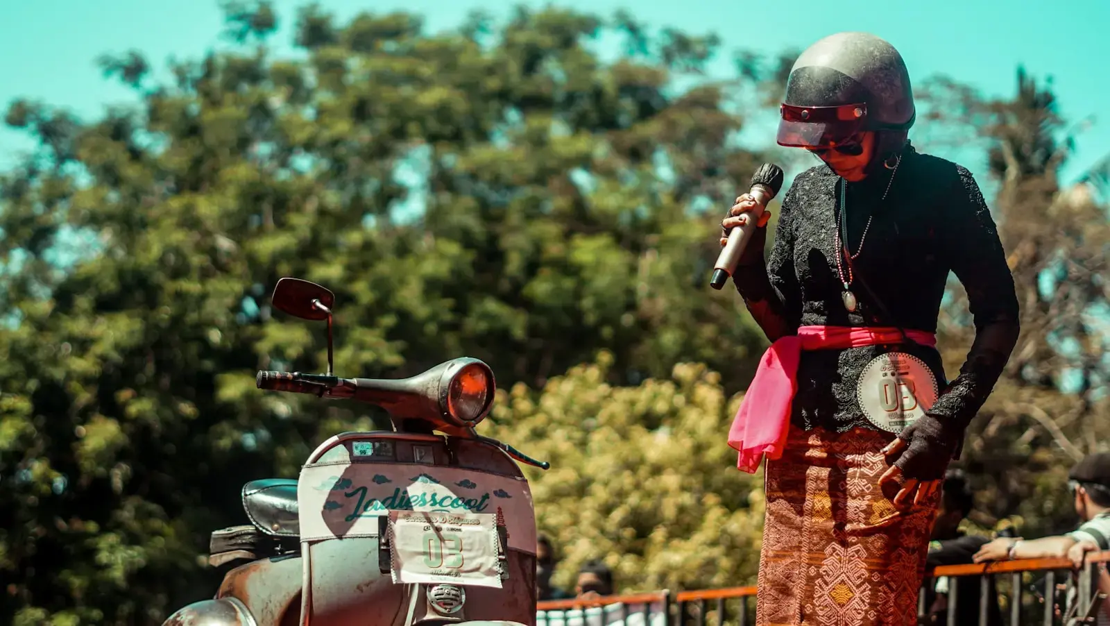 A person in a skeleton costume speaks into a mic.