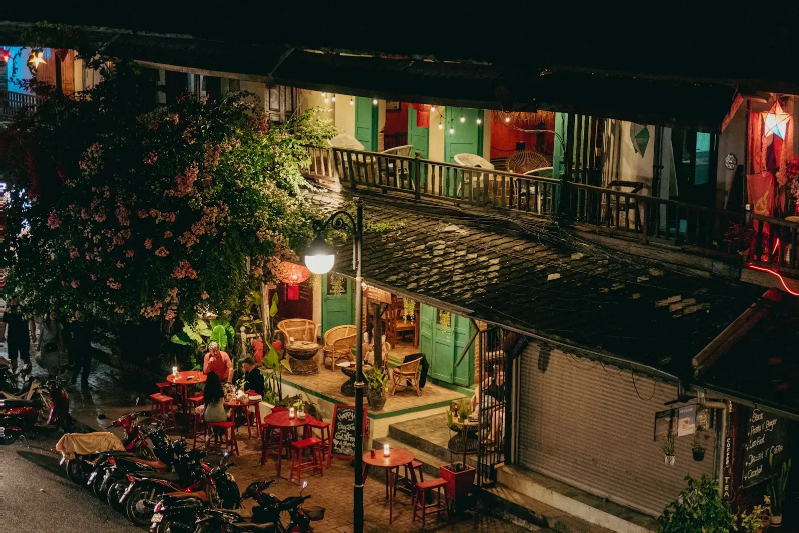 A night time view of a building with many tables and chairs