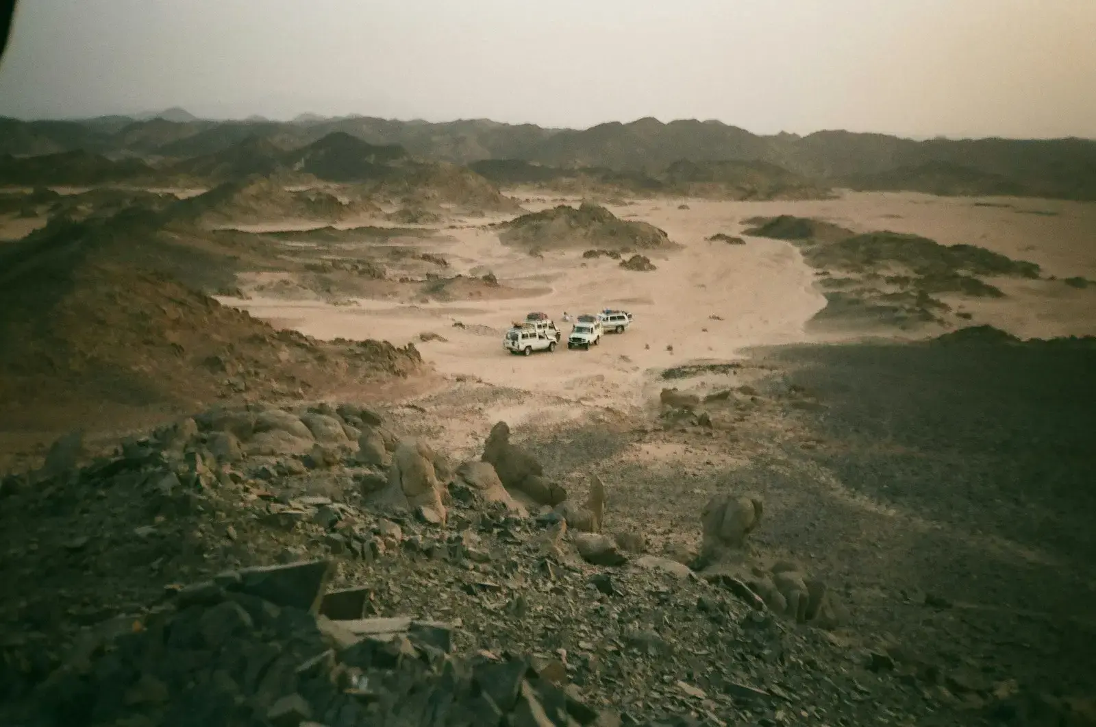 Photo by Youhana Nassif a group of vehicles parked in a desert