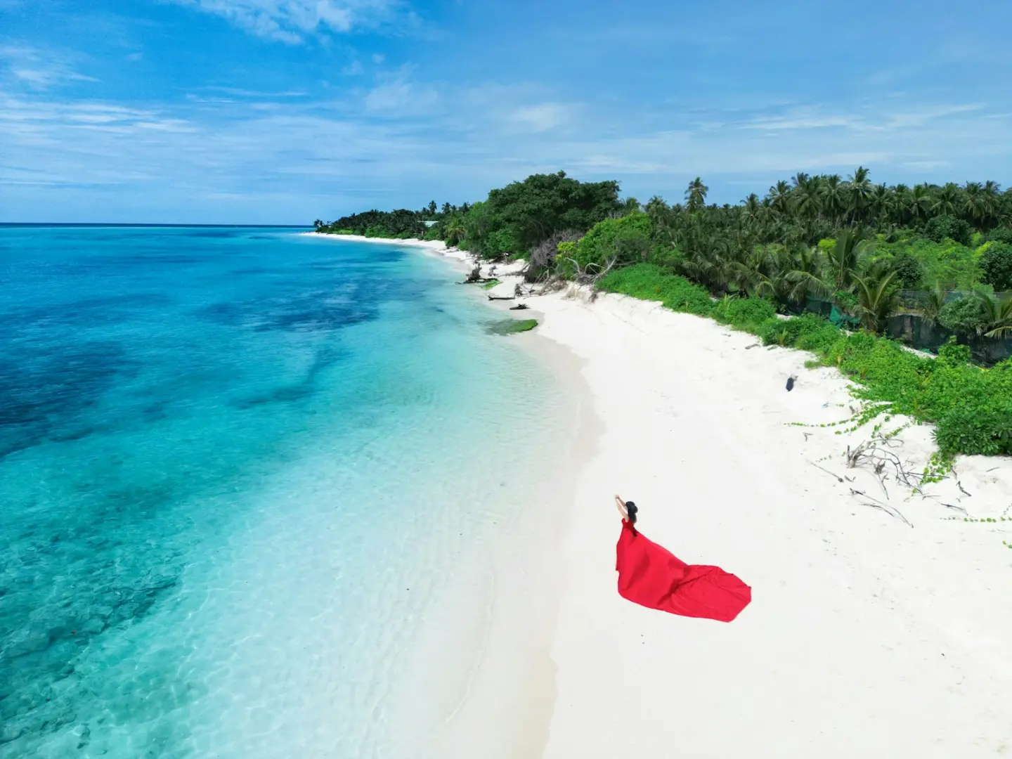 Woman in red dress on a tropical beach