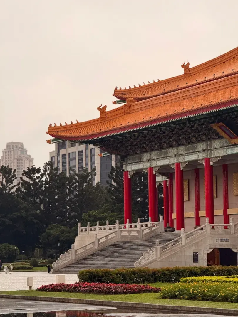 Photo by Artem Korolev Traditional building with red columns and orange roof.