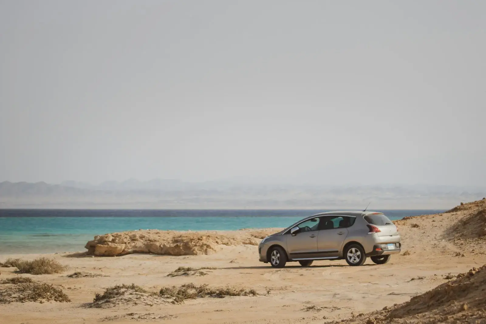 Photo by Jean-Baptiste D. a car parked on a beach