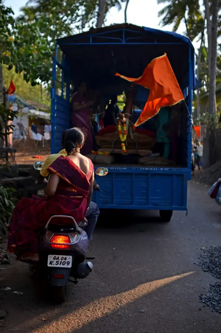 Photo by Tatiana Tochilova a woman sitting on a scooter in front of a blue truck
