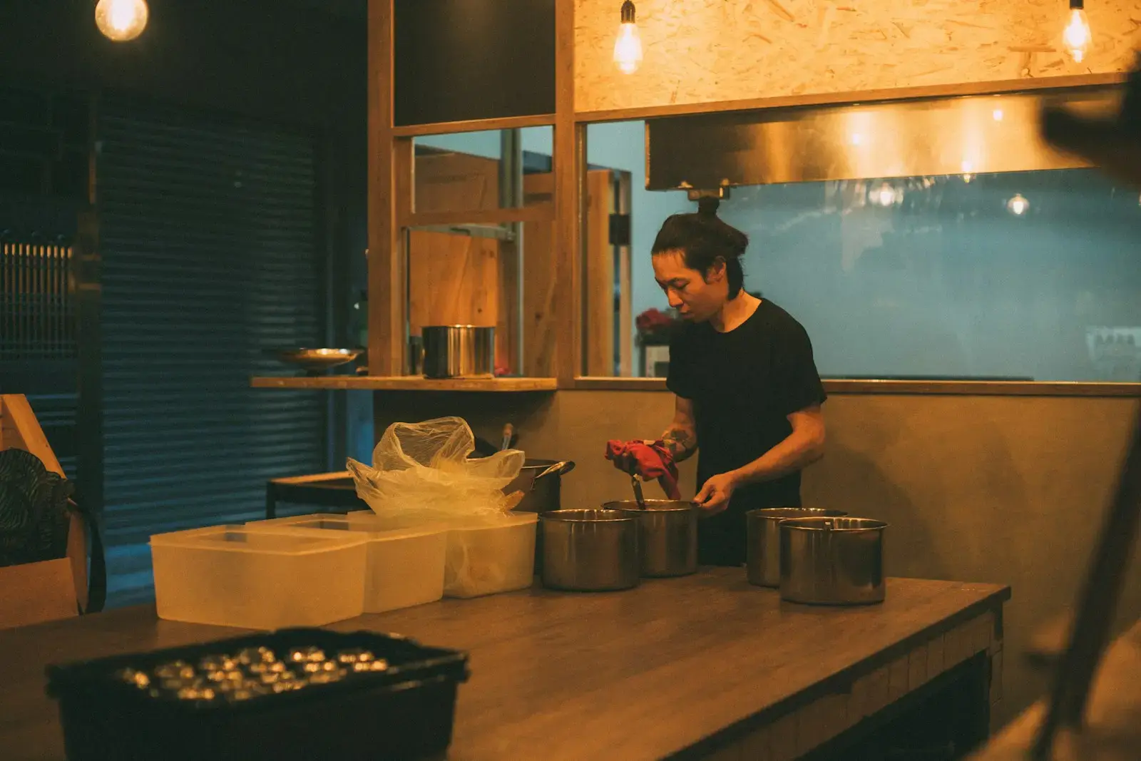 man standing in front of table with cooking pots