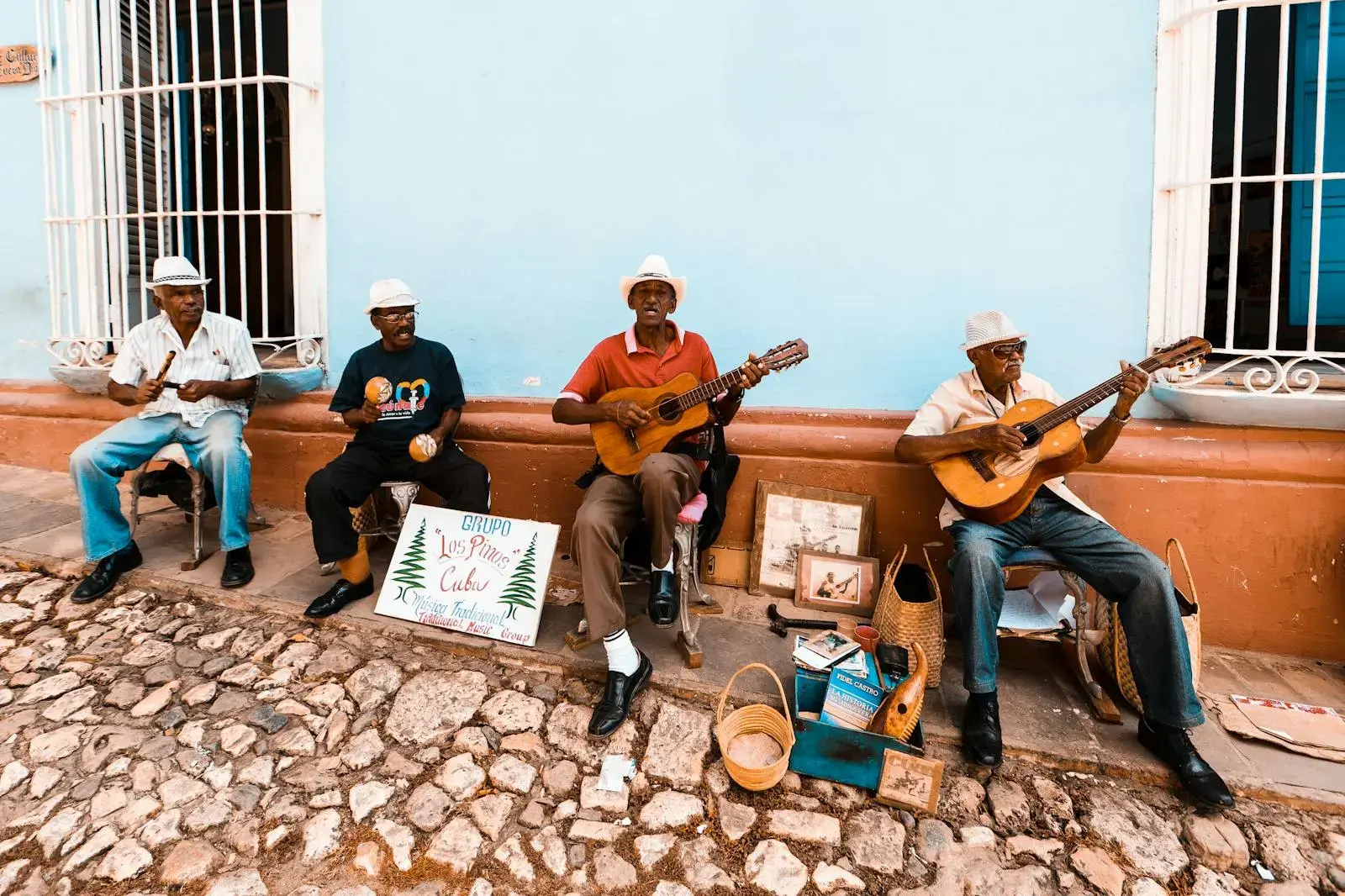 A group of elderly men playing guitars and maracas on a Cuban street, showcasing traditional music.
