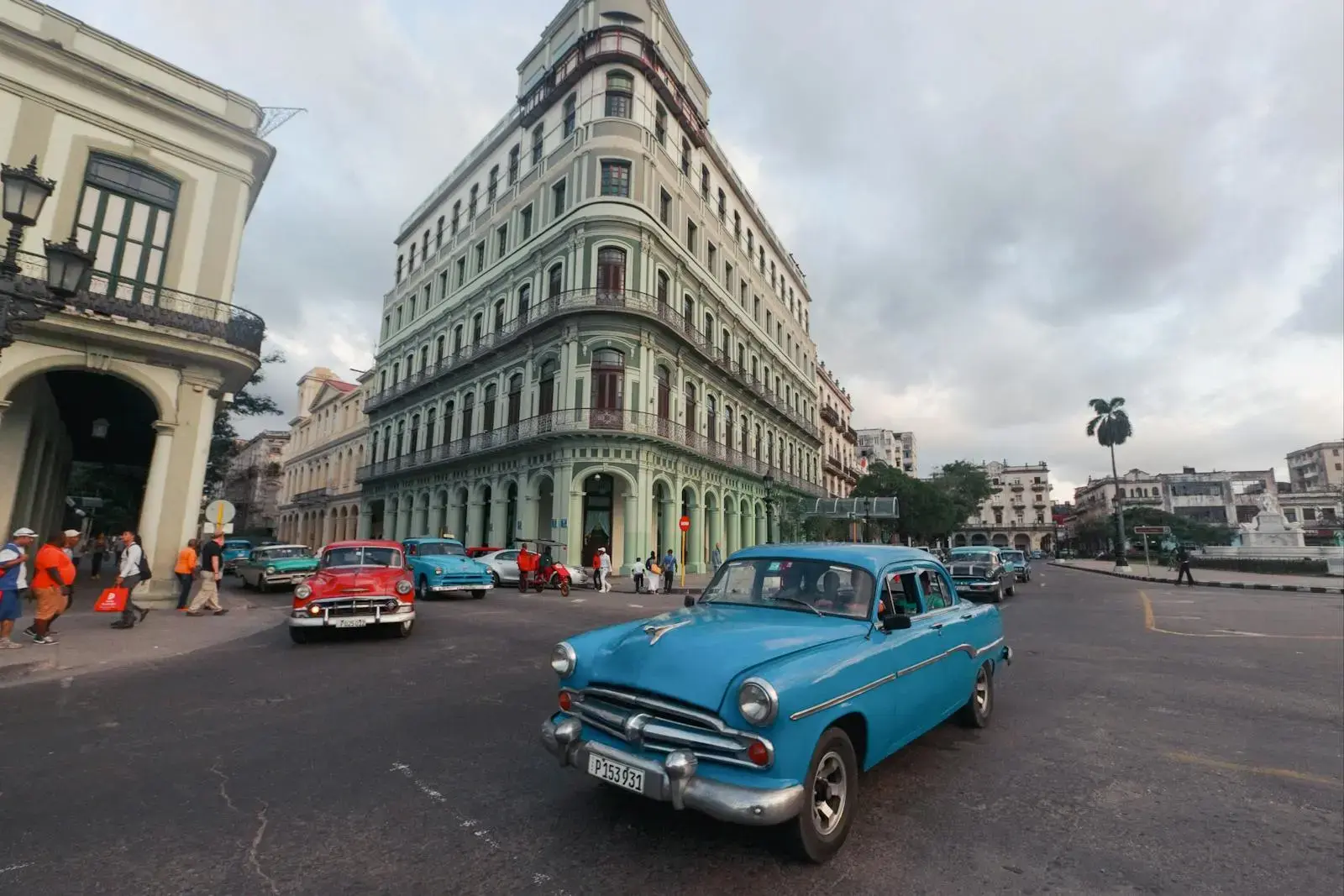 Classic cars and historic architecture on a vibrant Havana street corner, capturing Cuban culture.