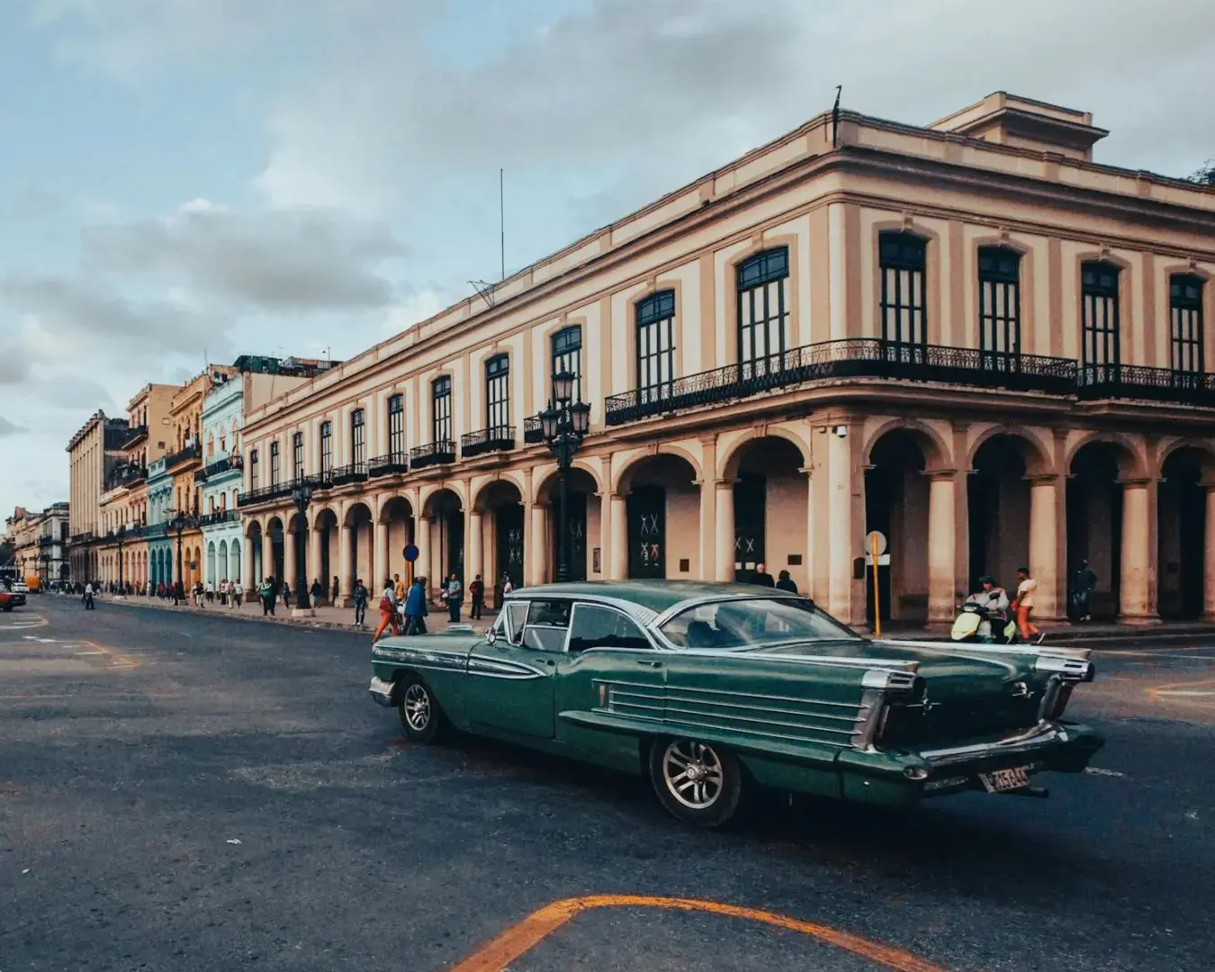 A retro car cruises along the historic streets of Havana, showcasing classical architecture.
