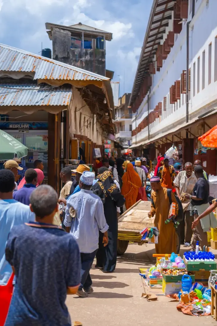 Photo by Aron Marinelli a group of people walking around a market