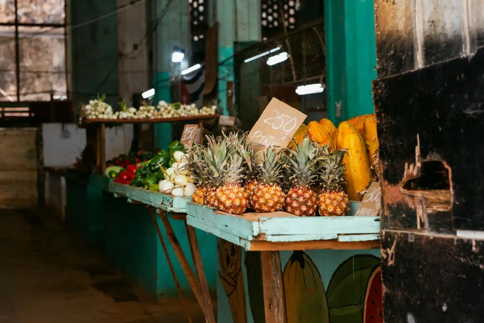 Photo by Marcelle Carvalho Explore a vibrant fruit stand in Havana, Cuba, showcasing fresh pineapples and tropical produce.