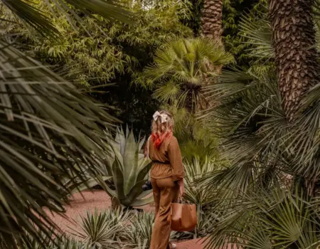 Woman walking through a lush green botanical garden.
