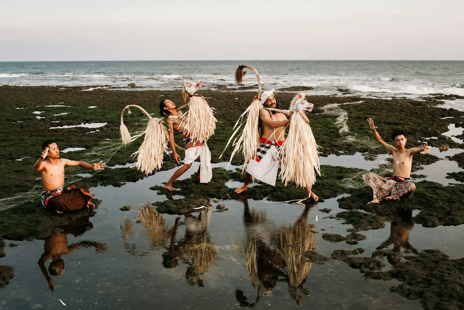 Dancers perform traditional ritual on rocky shore