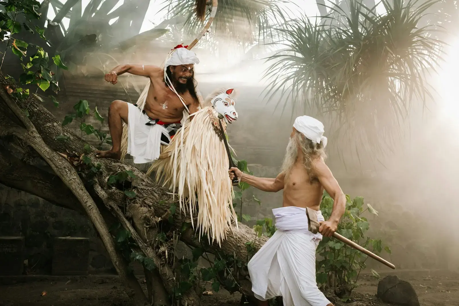 Two men in traditional attire performing a ritual outdoors.