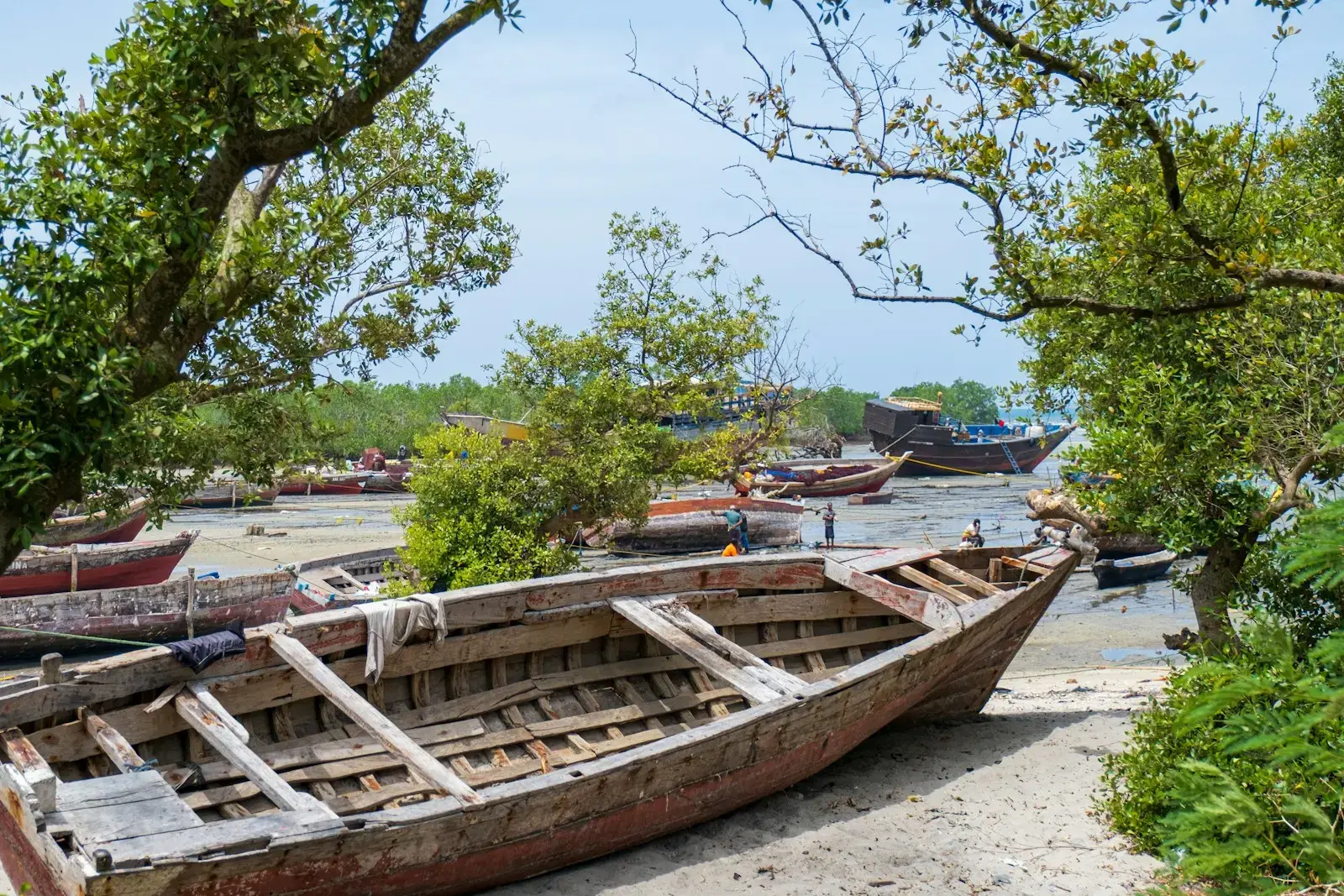 a wooden boat sitting on top of a sandy beach