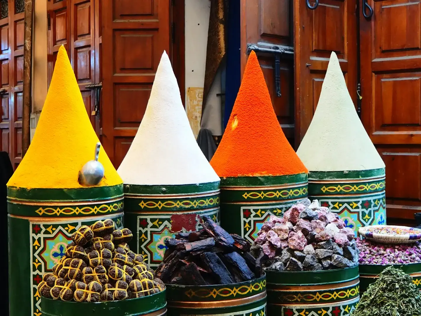 Photo by diego fabra Colorful spices displayed in conical piles at a market.