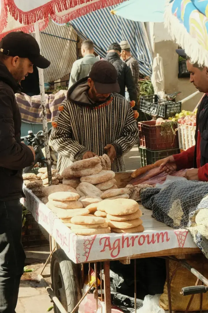 Photo by Denis A group of men standing around a table filled with food