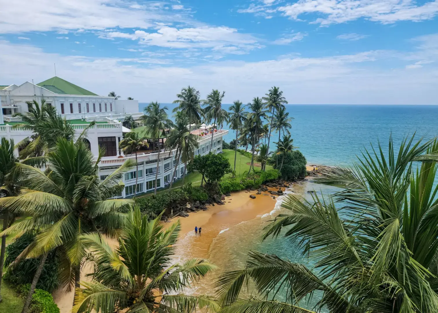 Beautiful beach with buildings and palm trees.