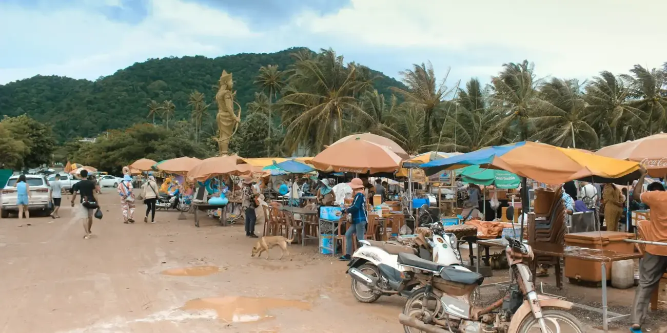 Outdoor market with stalls, motorcycles, and people