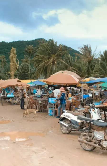 Outdoor market with stalls, motorcycles, and people
