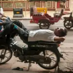 Čo sa oplatí zažiť v Kambodži? Man sleeping on a motorcycle on a city street