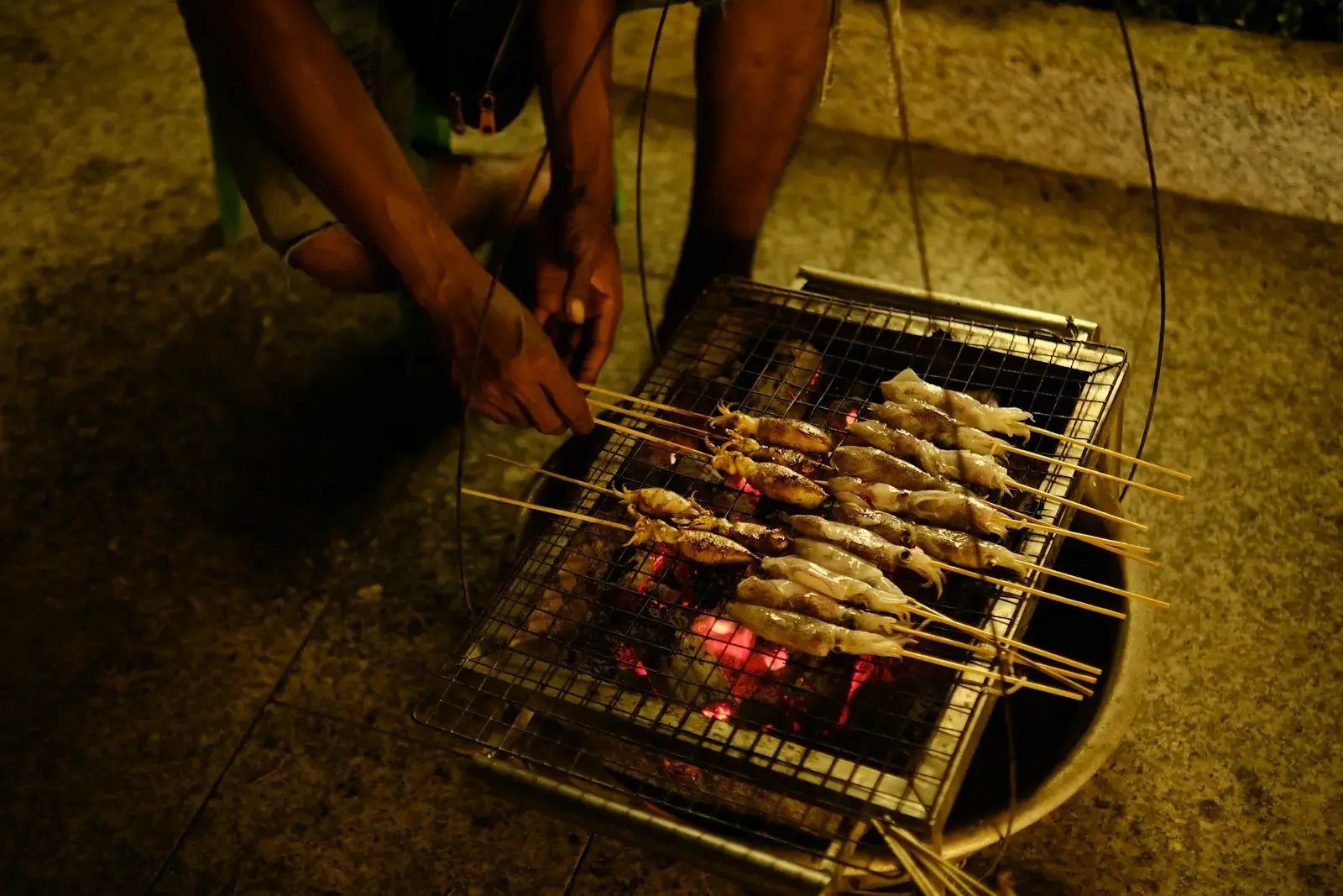 A man is cooking fish on a grill