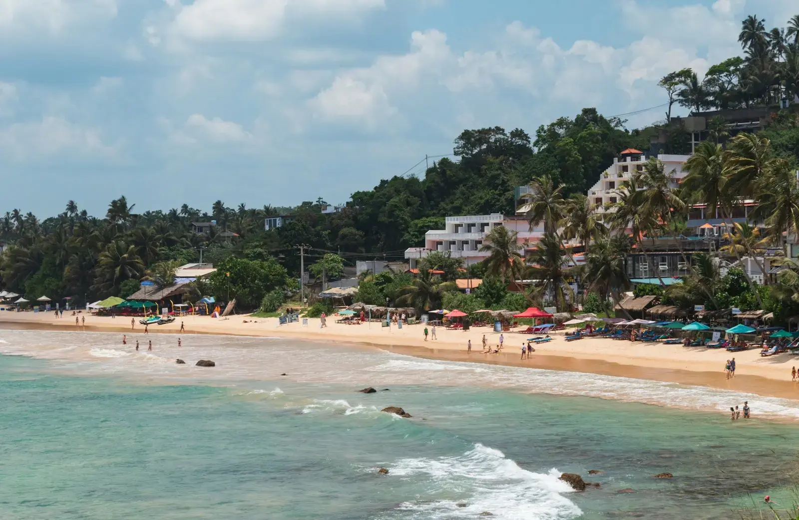 Tropical beach with buildings and palm trees.