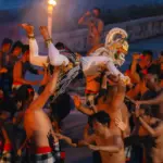 Dancers perform a traditional ritual with torches at night.